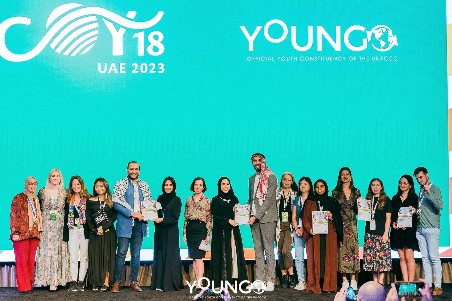 COY18 delegates holding the Global Youth Statement on stage at COY18 UAE
